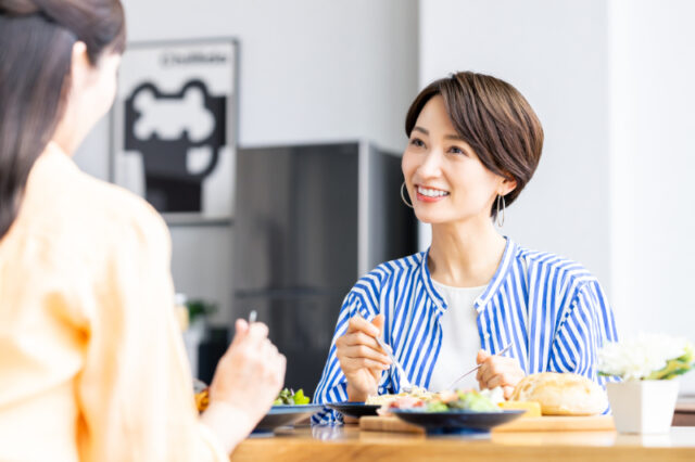 根管治療をし笑顔で食事をする女性